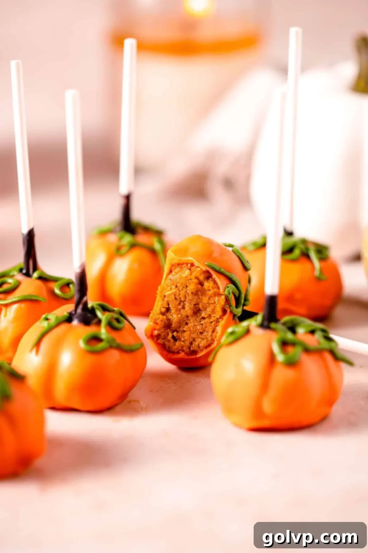 Pumpkin cake pops on warm toned marble with green vines