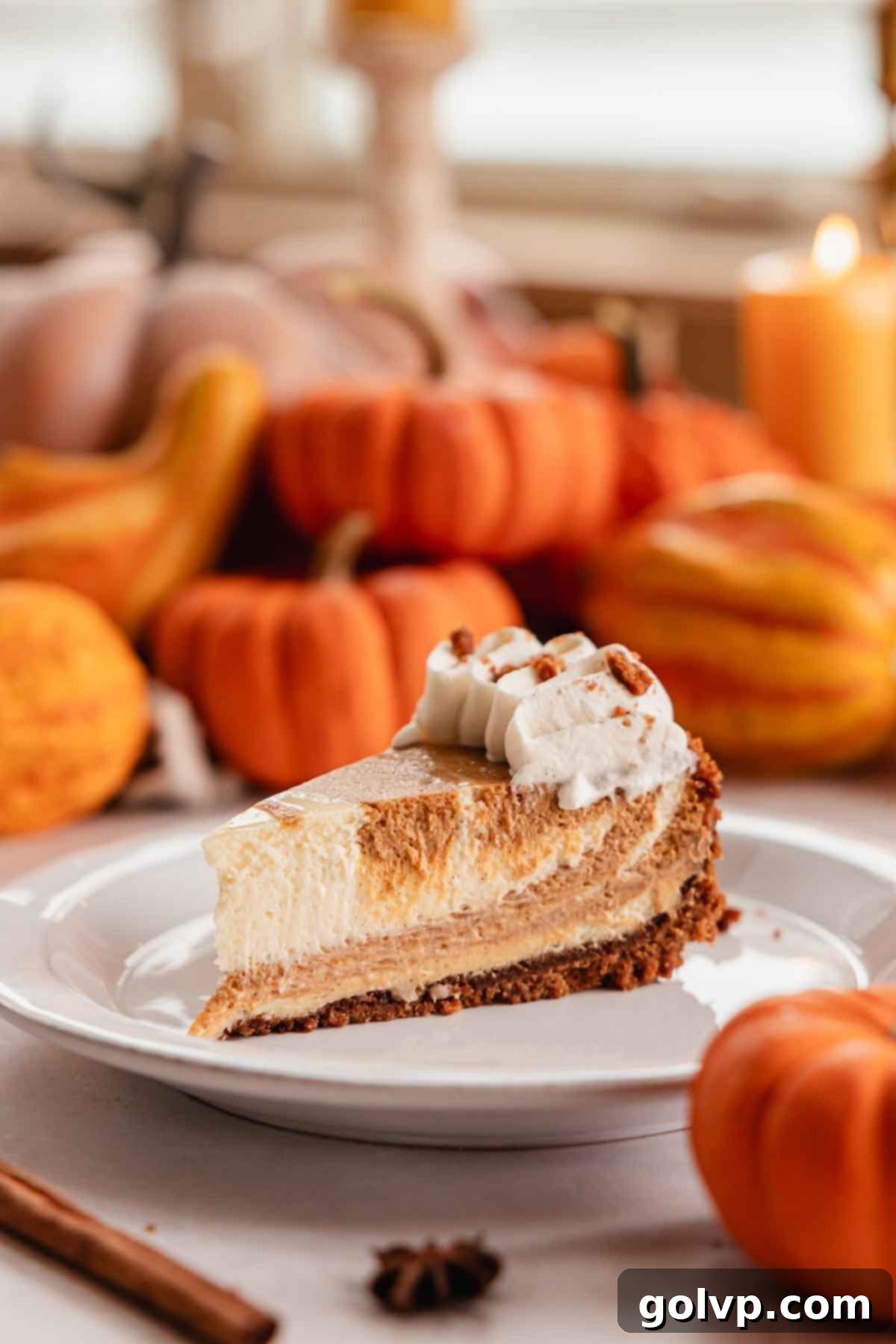 slice of pumpkin pie cheesecake on a plate with whipped cream
