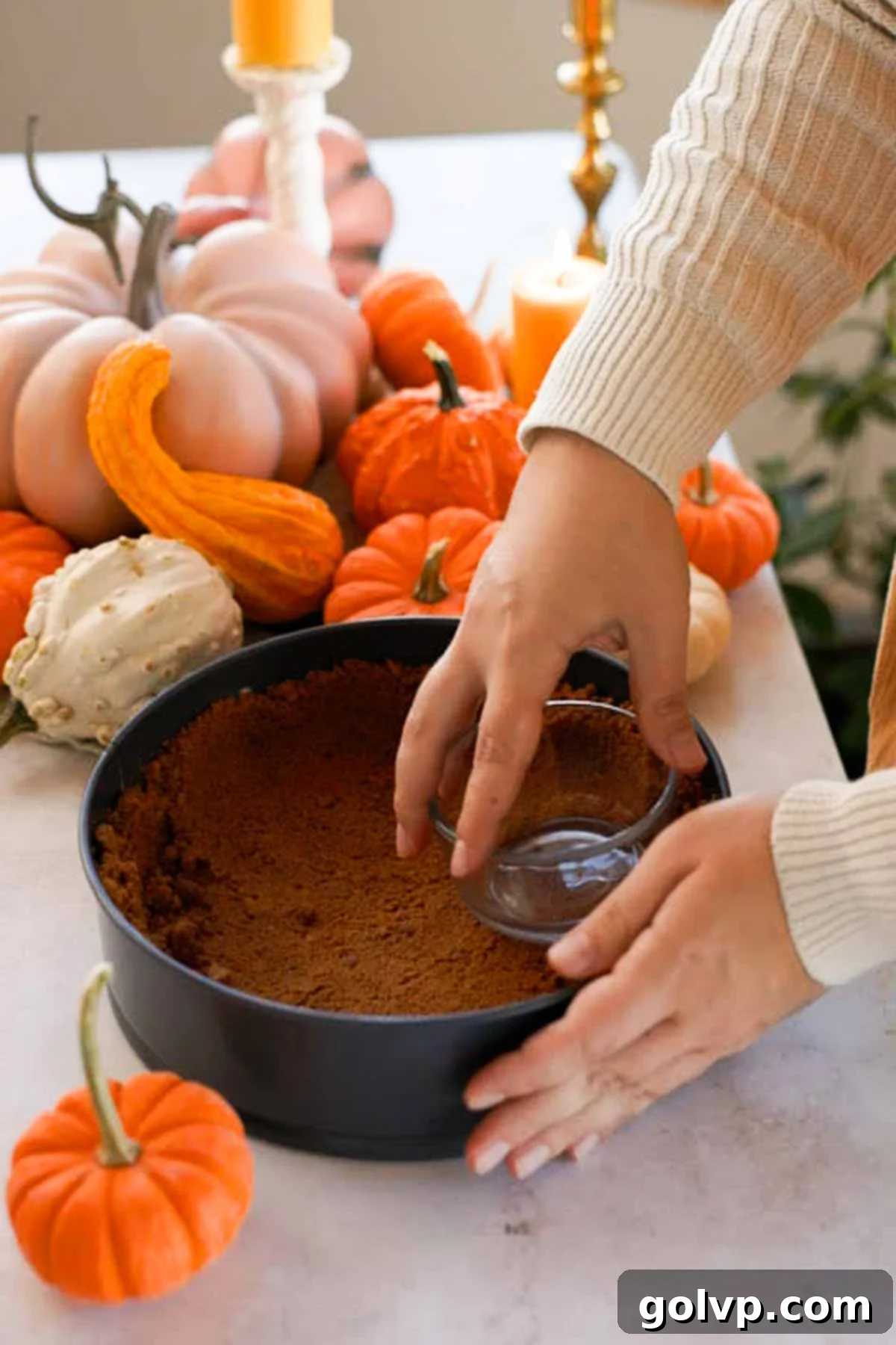 pressing biscoff crumbs into a springform pan