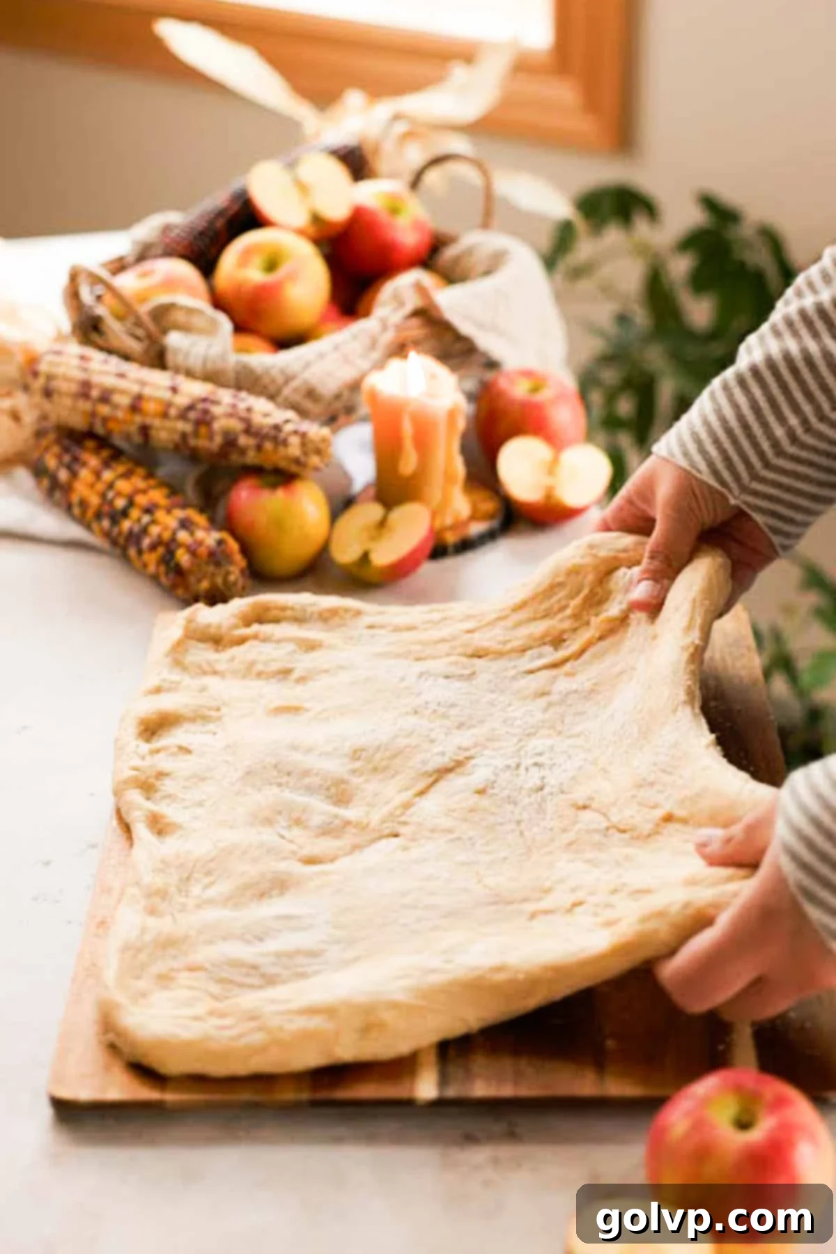 stretching donut dough into a rectangle on a cutting board