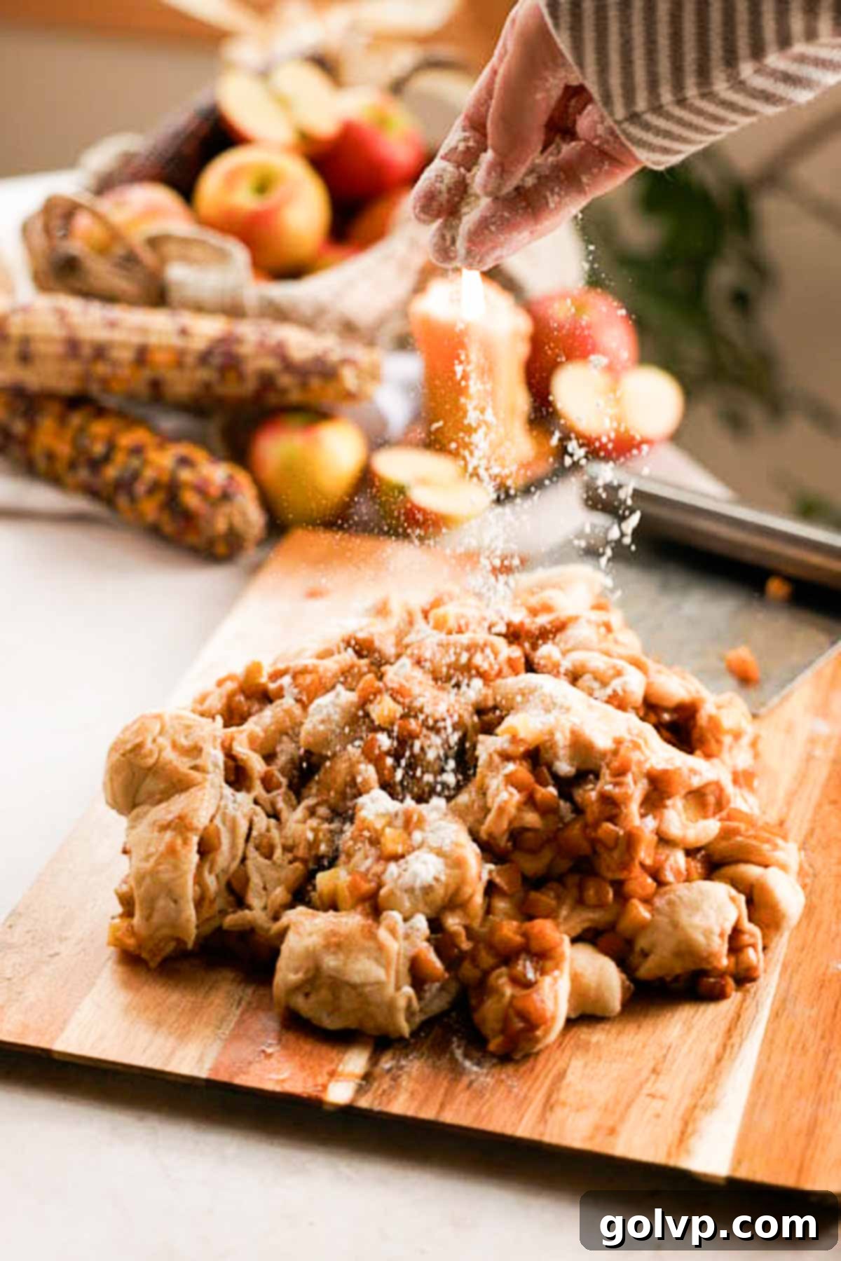 sprinkling apple fritter dough with apple filling with flour