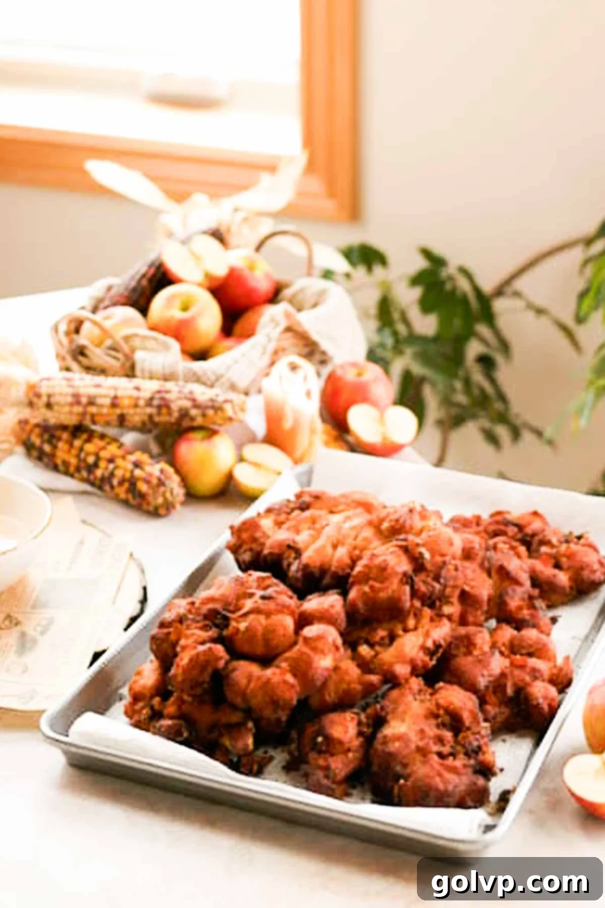 tray of apple fritters draining on paper towel
