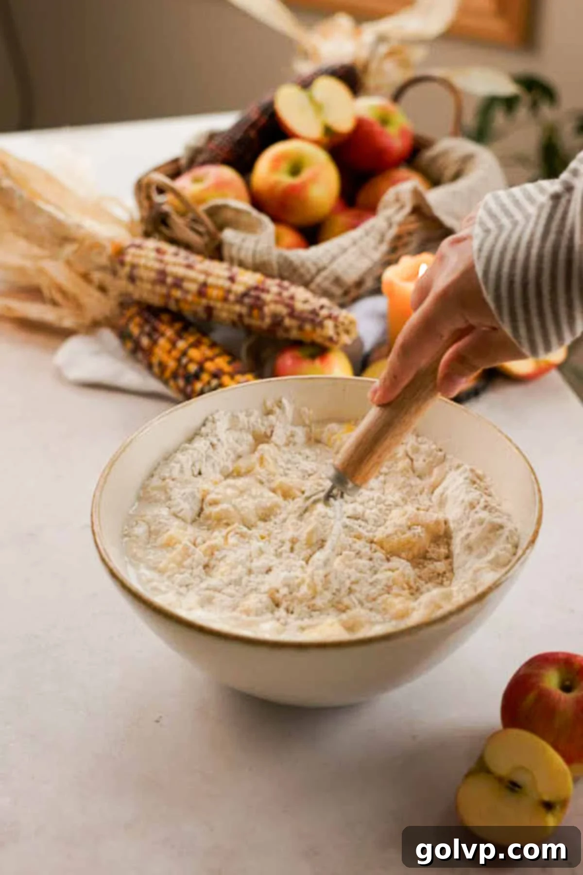 stirring no knead fritter dough together with a danish whisk in a large bowl