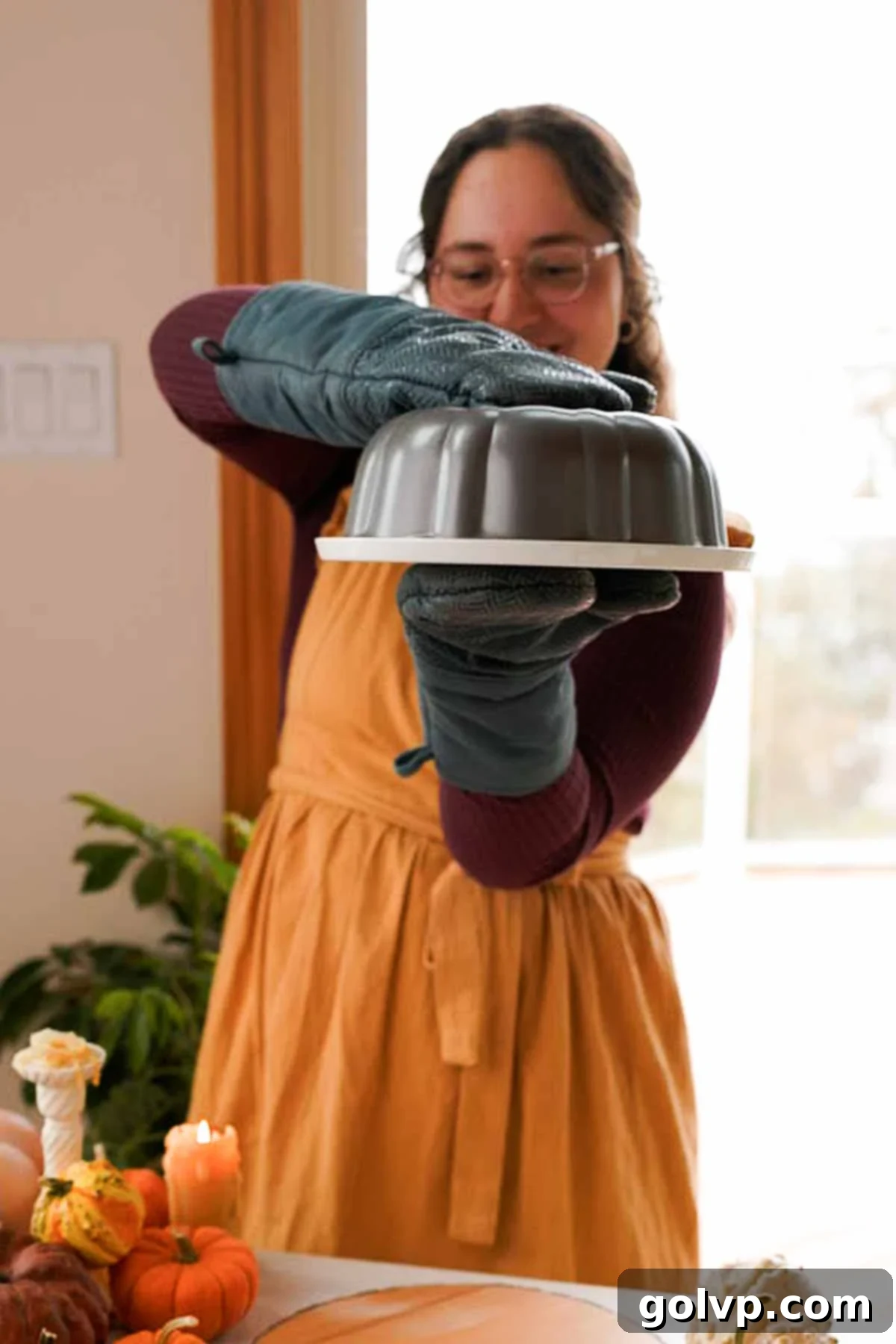 A freshly baked pumpkin monkey bread being inverted onto a large serving plate from a bundt pan.