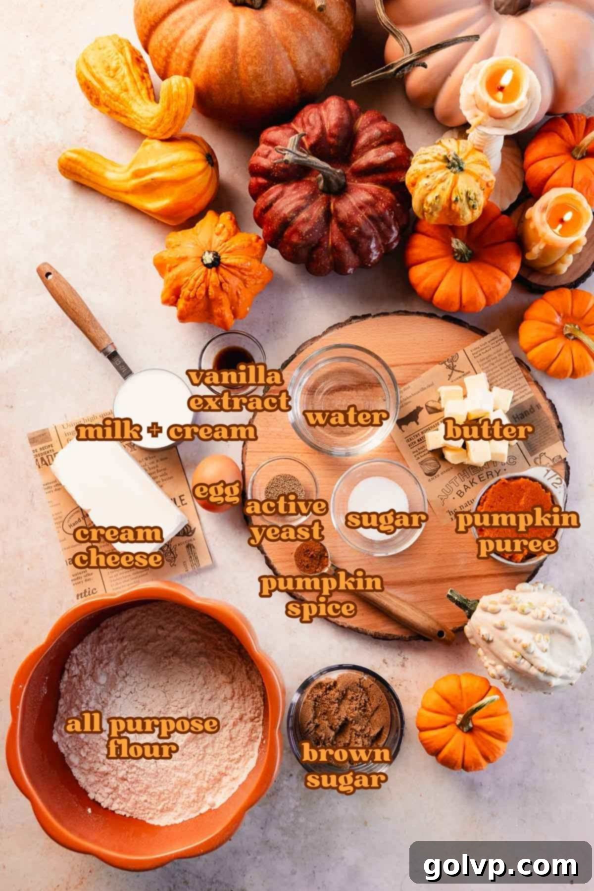 A collection of fresh ingredients in bowls for making pumpkin cream cheese monkey bread, including pumpkin puree, cream cheese, spices, and flour.