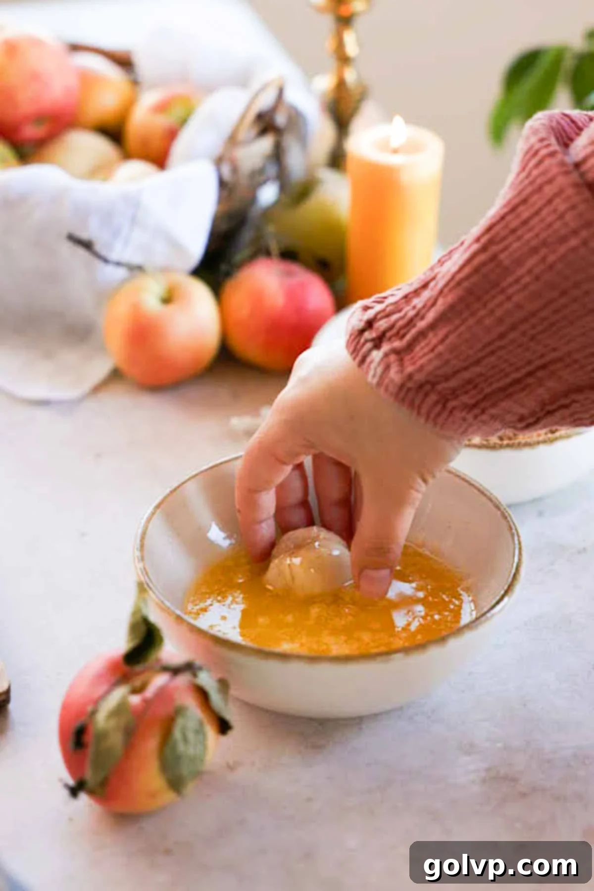 dipping caramel stuffed monkey bread ball into melted sugar