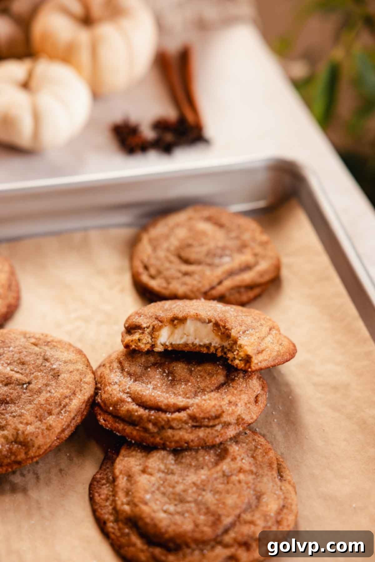 chai cookies on baking tray with one bitten to show cheesecake filling