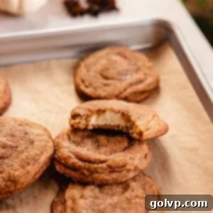chai cookies on baking tray with one bitten to show cheesecake filling